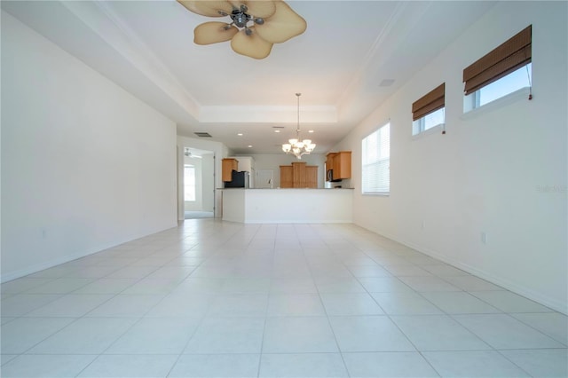 unfurnished living room with visible vents, baseboards, a tray ceiling, ornamental molding, and light tile patterned floors