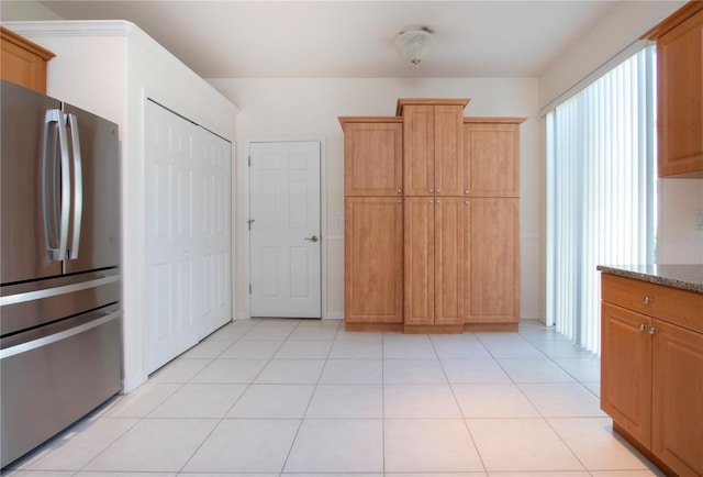 kitchen with light tile patterned floors and freestanding refrigerator