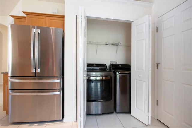 clothes washing area with light tile patterned floors, laundry area, and washing machine and dryer