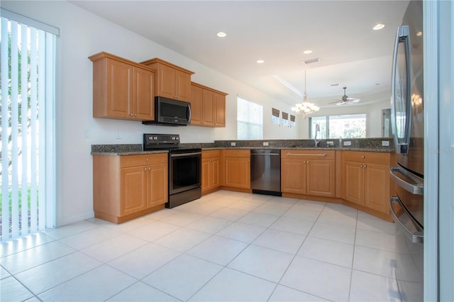 kitchen featuring a sink, dark stone counters, appliances with stainless steel finishes, and recessed lighting