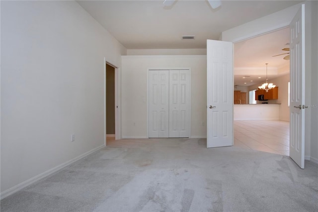 unfurnished bedroom featuring visible vents, baseboards, light tile patterned flooring, a closet, and light colored carpet