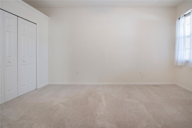 unfurnished bedroom featuring a closet, baseboards, and carpet