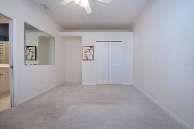 unfurnished bedroom with baseboards, visible vents, a closet, and light carpet