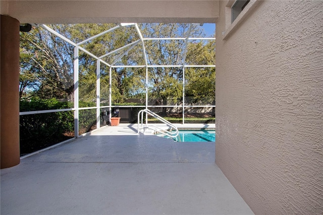 outdoor pool featuring a patio area and glass enclosure