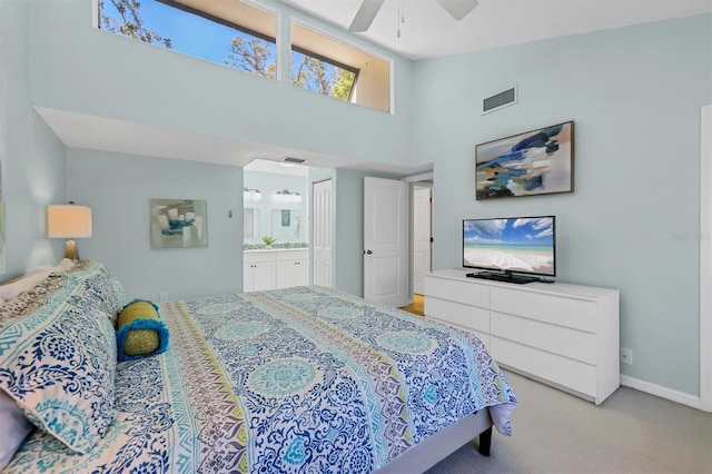 bedroom with baseboards, visible vents, high vaulted ceiling, ensuite bath, and light colored carpet