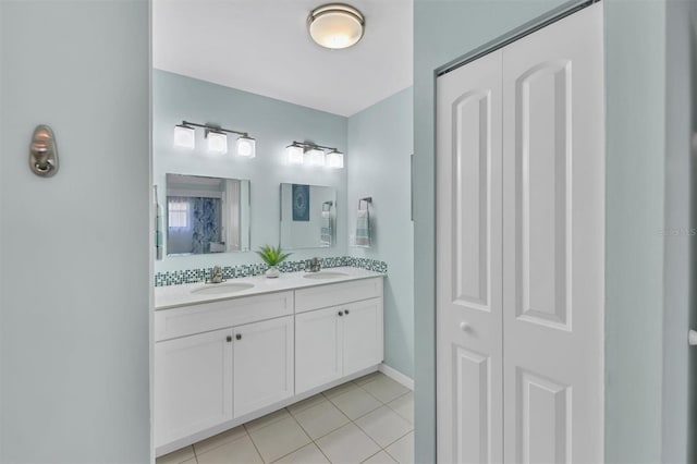 full bath featuring double vanity, a closet, tile patterned flooring, and a sink