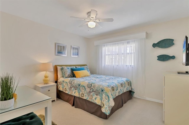 bedroom featuring baseboards, light carpet, and a ceiling fan