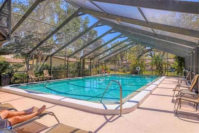 pool with glass enclosure and a patio