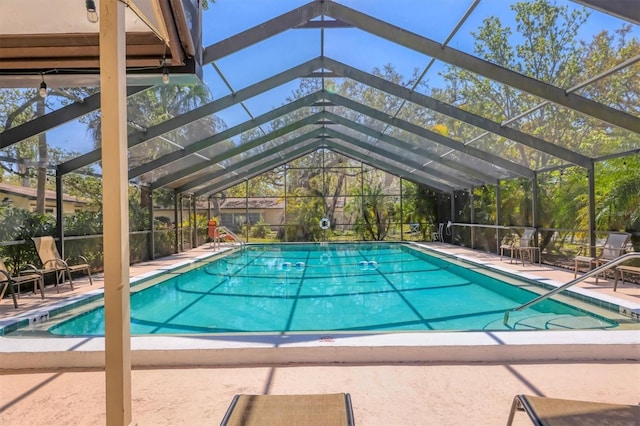 community pool featuring glass enclosure and a patio