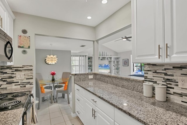 kitchen featuring white cabinetry, electric range, light tile patterned floors, and light stone countertops