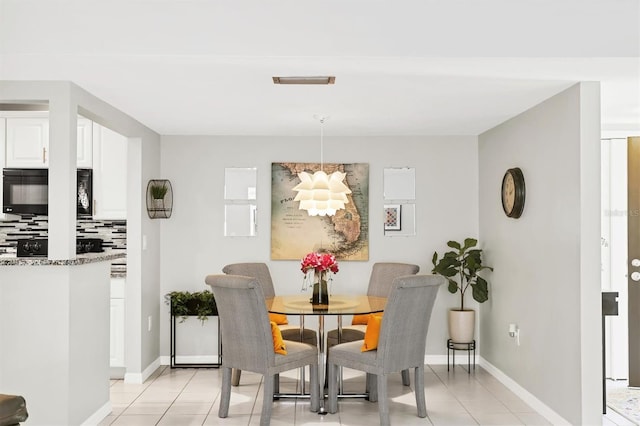 dining area featuring light tile patterned flooring and baseboards