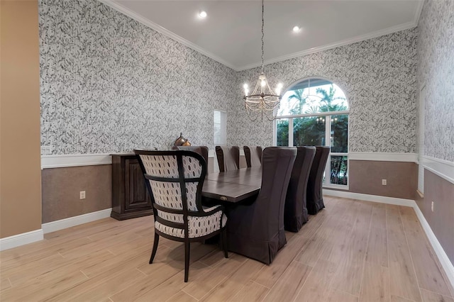 dining area with light wood-type flooring, ornamental molding, wainscoting, and wallpapered walls