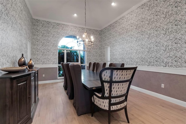 dining room featuring wallpapered walls, a wainscoted wall, ornamental molding, light wood-style flooring, and a notable chandelier