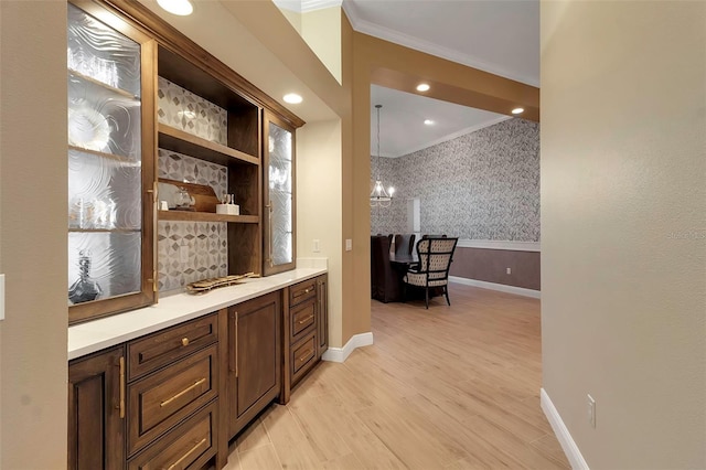 bar featuring baseboards, wallpapered walls, recessed lighting, ornamental molding, and light wood-style floors