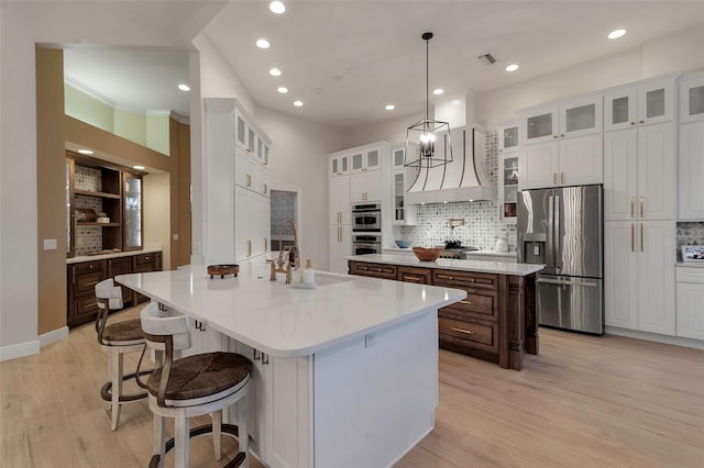 kitchen featuring visible vents, light wood-style flooring, a sink, appliances with stainless steel finishes, and a center island