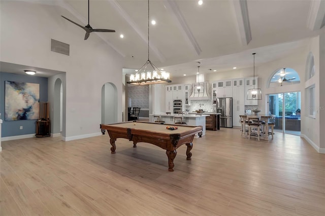 game room featuring high vaulted ceiling, arched walkways, light wood-type flooring, and ceiling fan