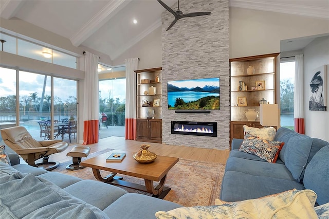 living area featuring beam ceiling, high vaulted ceiling, wood finished floors, a fireplace, and crown molding