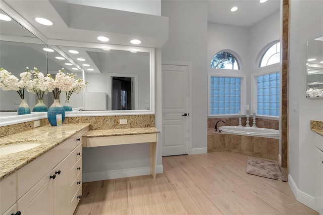 bathroom with vanity, a garden tub, baseboards, and wood tiled floor