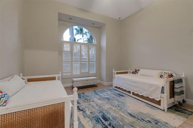 bedroom featuring light wood finished floors and baseboards