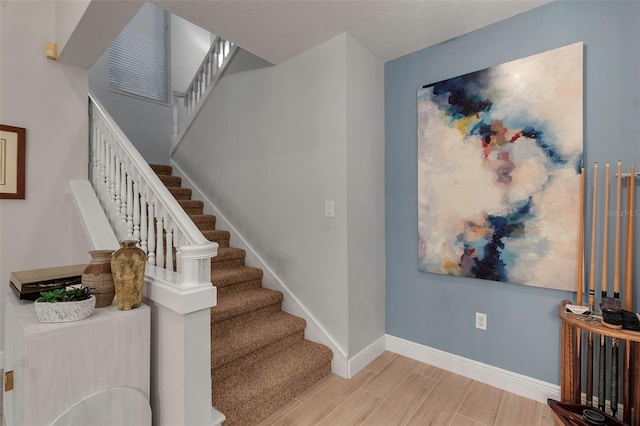 stairs with wood finish floors and baseboards