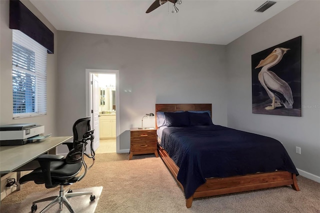 bedroom featuring visible vents, ensuite bathroom, a ceiling fan, baseboards, and light colored carpet