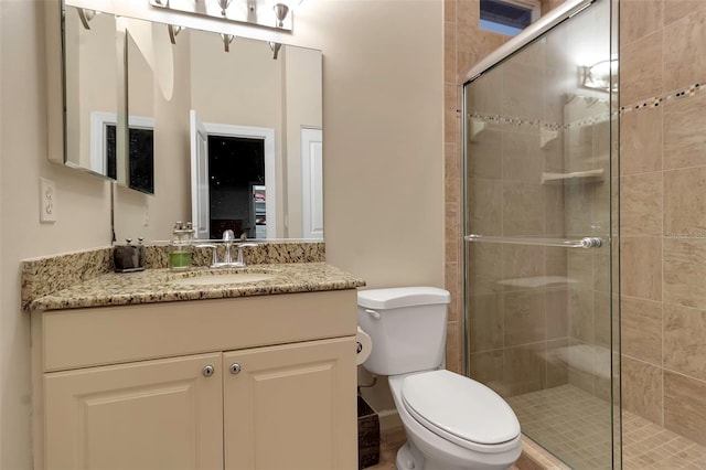 full bathroom with a shower stall, toilet, and vanity