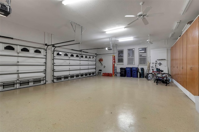 garage with a garage door opener and a ceiling fan