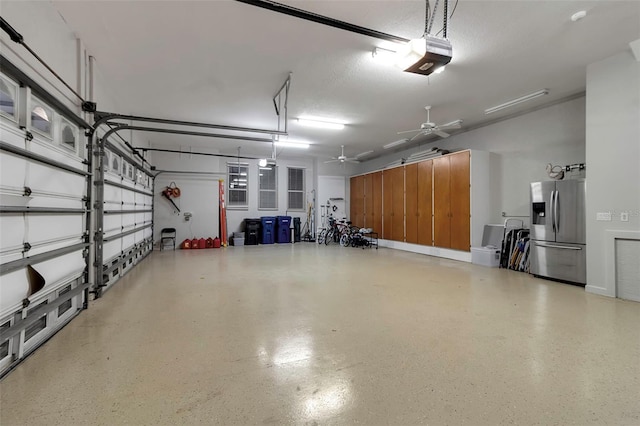 garage featuring stainless steel fridge and a garage door opener