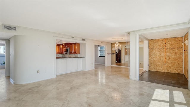 unfurnished living room with visible vents, baseboards, and an inviting chandelier