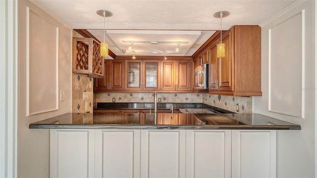 kitchen with stainless steel microwave, dark countertops, and a peninsula