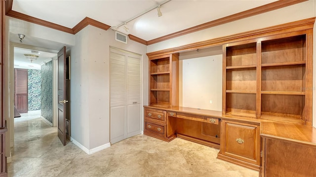 unfurnished office featuring track lighting, visible vents, crown molding, baseboards, and built in desk