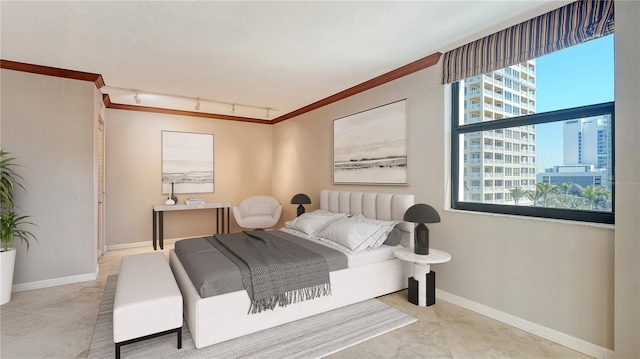 bedroom featuring crown molding, a view of city, baseboards, and track lighting