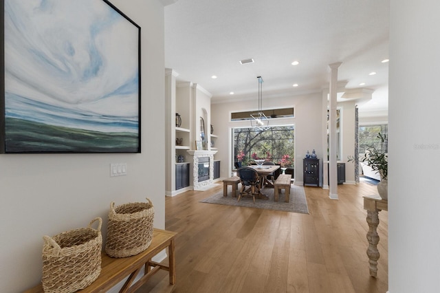 dining area with light wood-type flooring, built in shelves, visible vents, recessed lighting, and crown molding