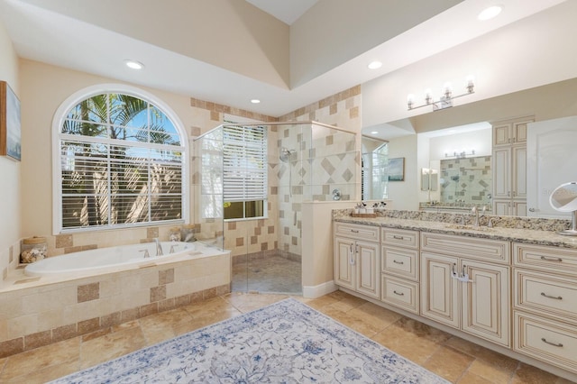 bathroom featuring a garden tub, a stall shower, a sink, recessed lighting, and double vanity