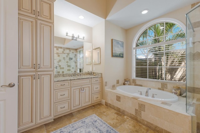 bathroom featuring vanity, a garden tub, and a stall shower