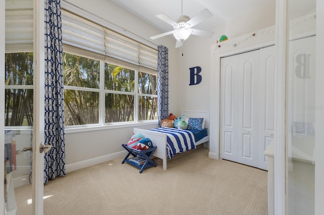 bedroom with a closet, a ceiling fan, baseboards, and carpet floors