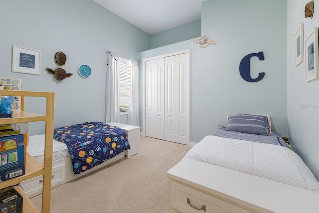 bedroom with a closet and light carpet