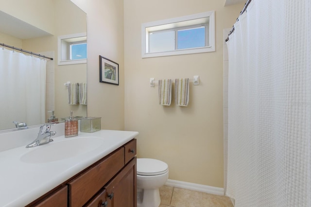 bathroom with baseboards, toilet, a healthy amount of sunlight, and tile patterned flooring