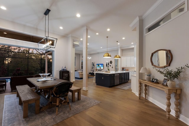 dining space with crown molding, baseboards, a chandelier, recessed lighting, and light wood-style flooring