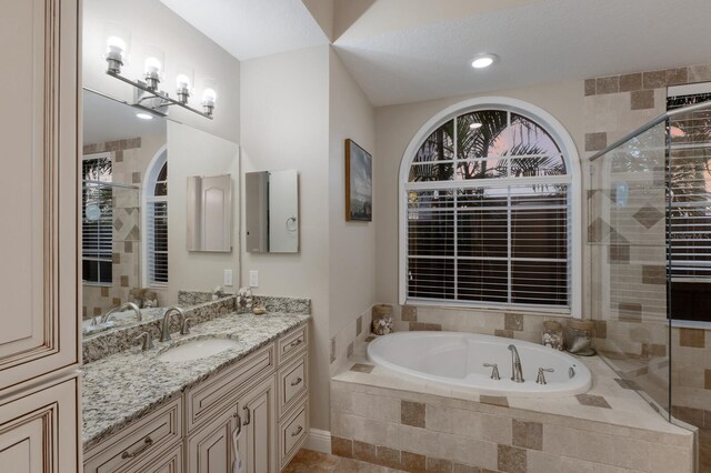 bathroom featuring a stall shower, a bath, and vanity