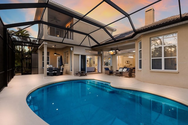 outdoor pool featuring a lanai, outdoor lounge area, a patio, and a ceiling fan