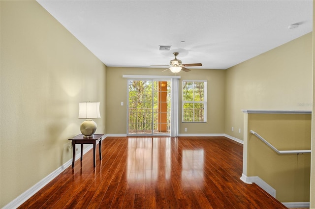 empty room featuring visible vents, baseboards, a ceiling fan, and hardwood / wood-style floors