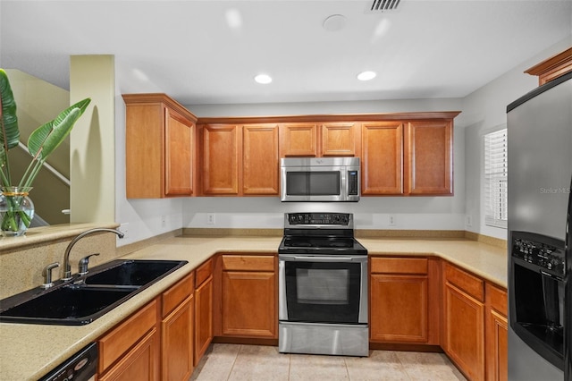 kitchen featuring a sink, stainless steel appliances, and light countertops