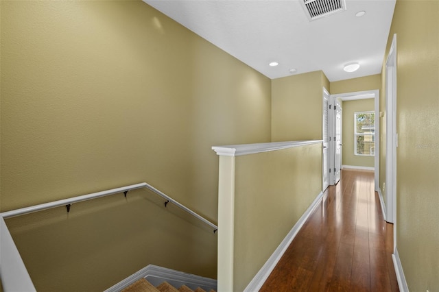 corridor with visible vents, baseboards, an upstairs landing, recessed lighting, and wood finished floors