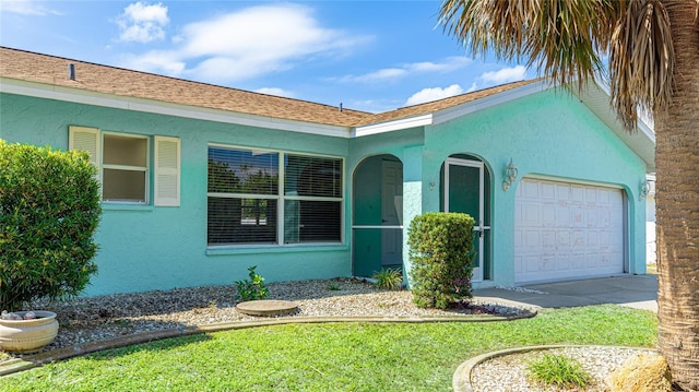 ranch-style home featuring stucco siding, an attached garage, and concrete driveway