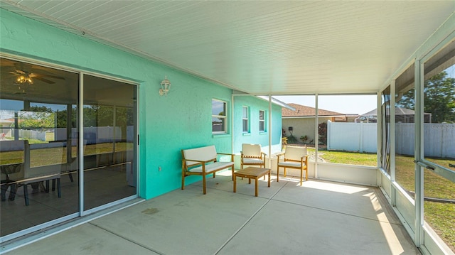 unfurnished sunroom with ceiling fan