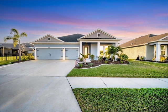 view of front of home with fence, stucco siding, driveway, a yard, and an attached garage