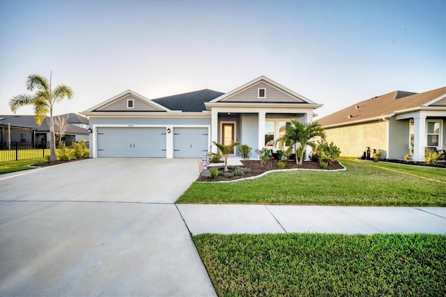 view of front of house featuring a front yard, concrete driveway, an attached garage, and fence