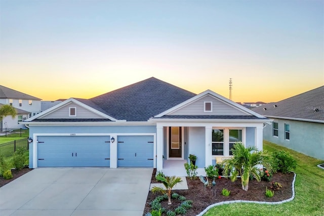 view of front of property featuring stucco siding, an attached garage, concrete driveway, and fence