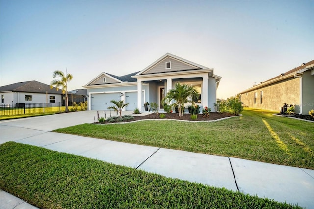 view of front of house with an attached garage, fence, a front yard, stucco siding, and driveway